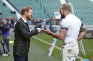 Prince Harry talking and smiling with James Haskell in a rugby stadium