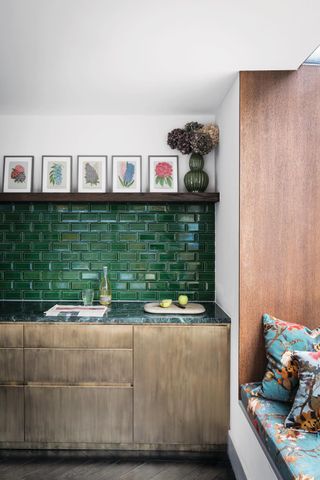 A kitchen with an emerald green subway tile backsplash and wooden cabinetry