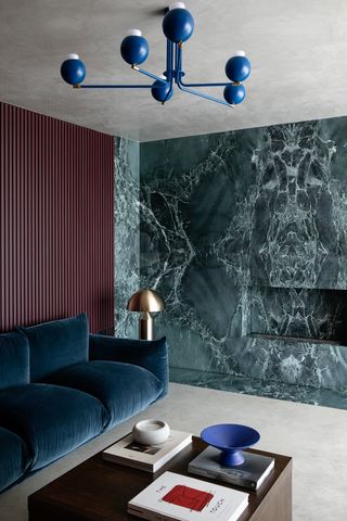 A deep, dark blue sofa placed against a brown wall
