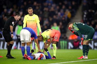 Leicester’s Kelechi Iheanacho receives attention after a collision with Manchester City goalkeeper Ederson, right