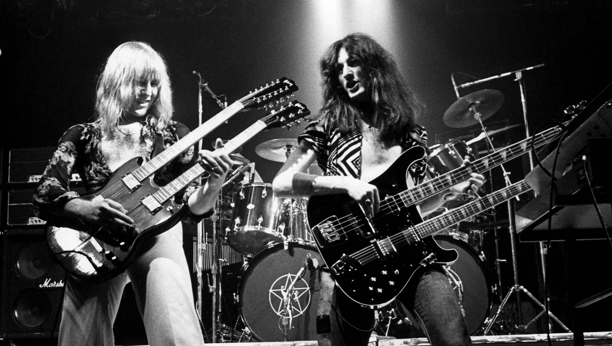 Alex Lifeson (playing Gibson EDS-175 double neck guitar), Geddy Lee (playing Rickenbacker 4080 double neck guitar) performing live onstage on All The World&#039;s A Stage tour, May 1977