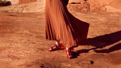 person wearing fisherman sandals waist-down photo with pleated skirt