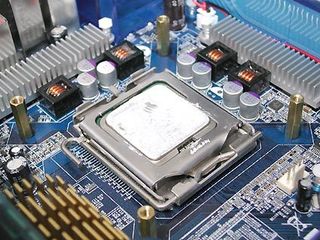 A look at the CPU now inserted into its LGA 775 socket, with all four hexagonal brass standoffs.