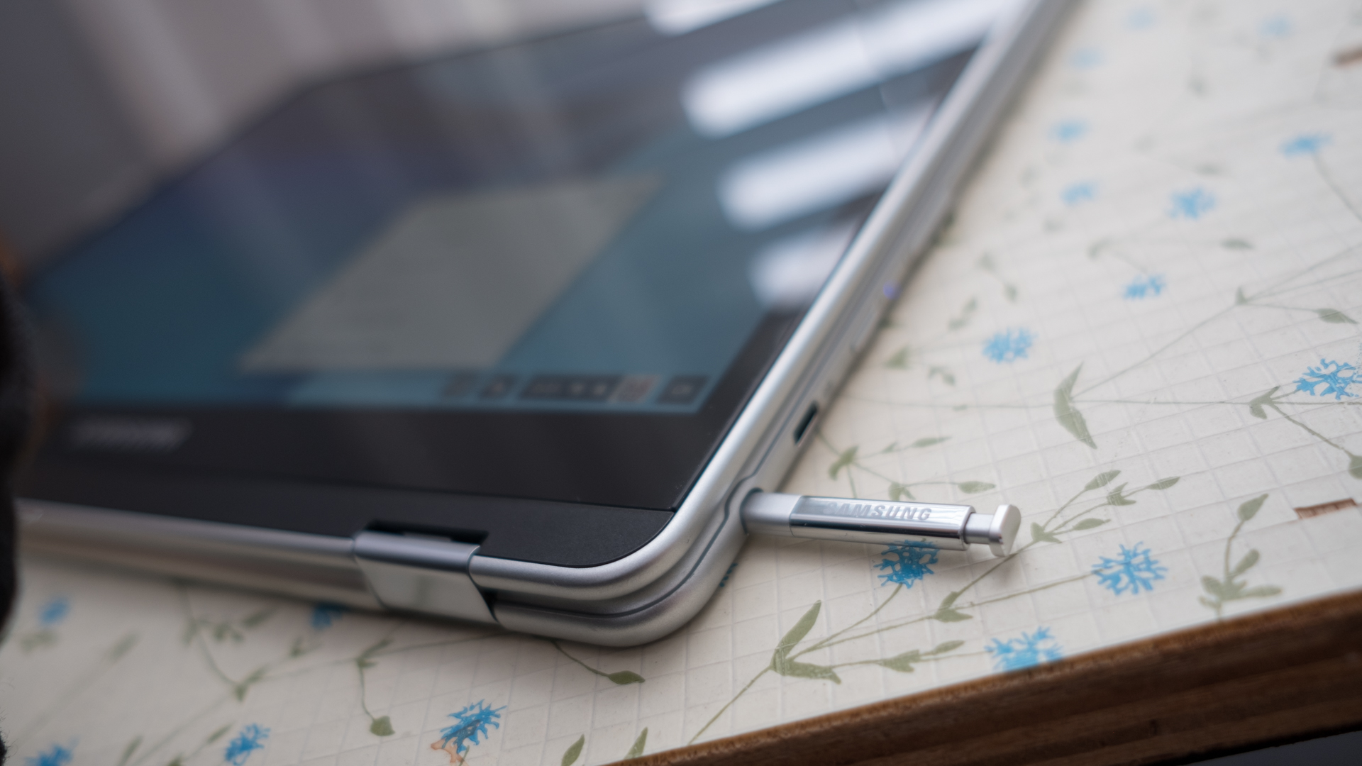 A stylus sticking out from the docking port of a 2-in-1 Chromebook