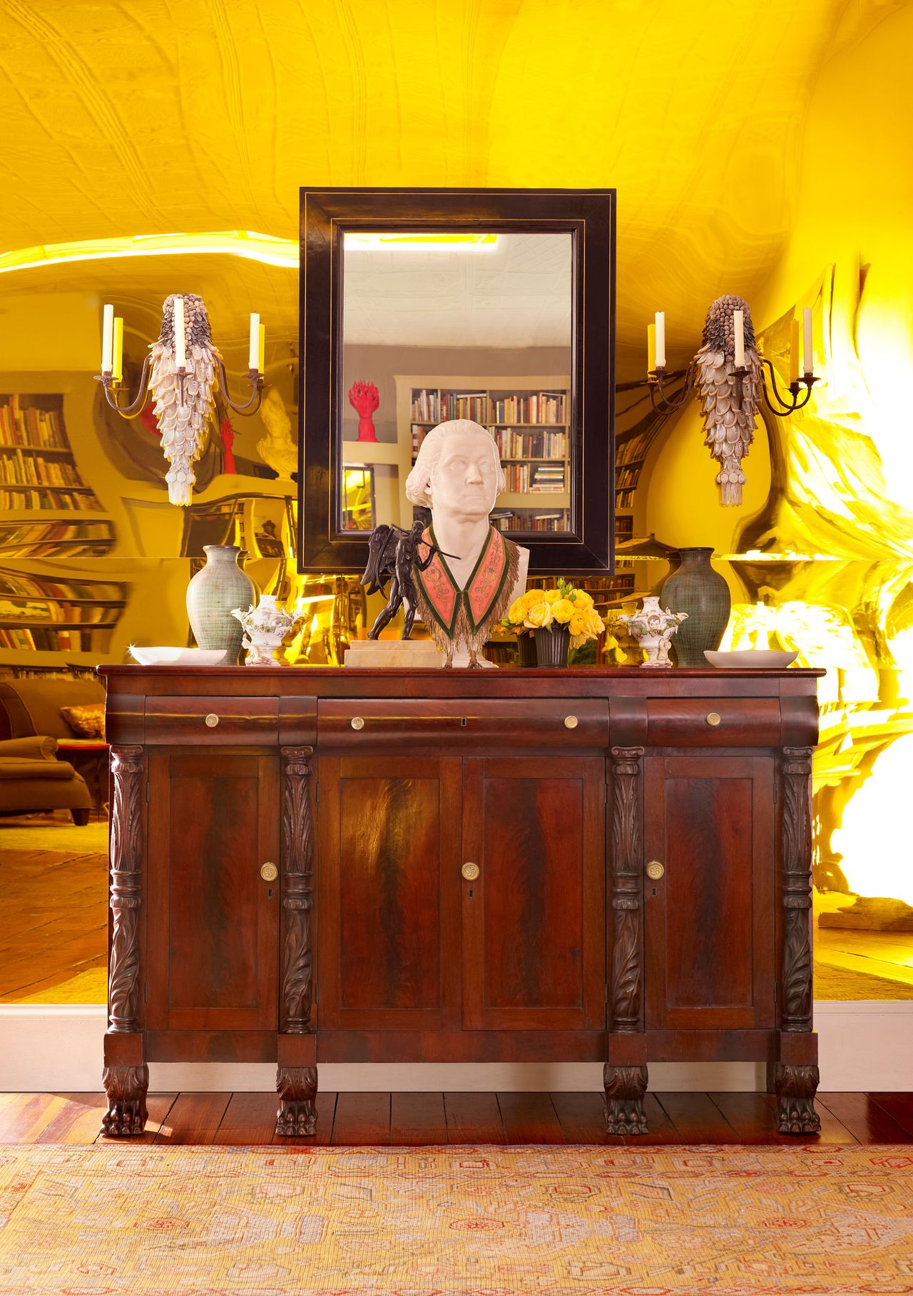 Wooden dresser against reflective gold yellow reflective wall