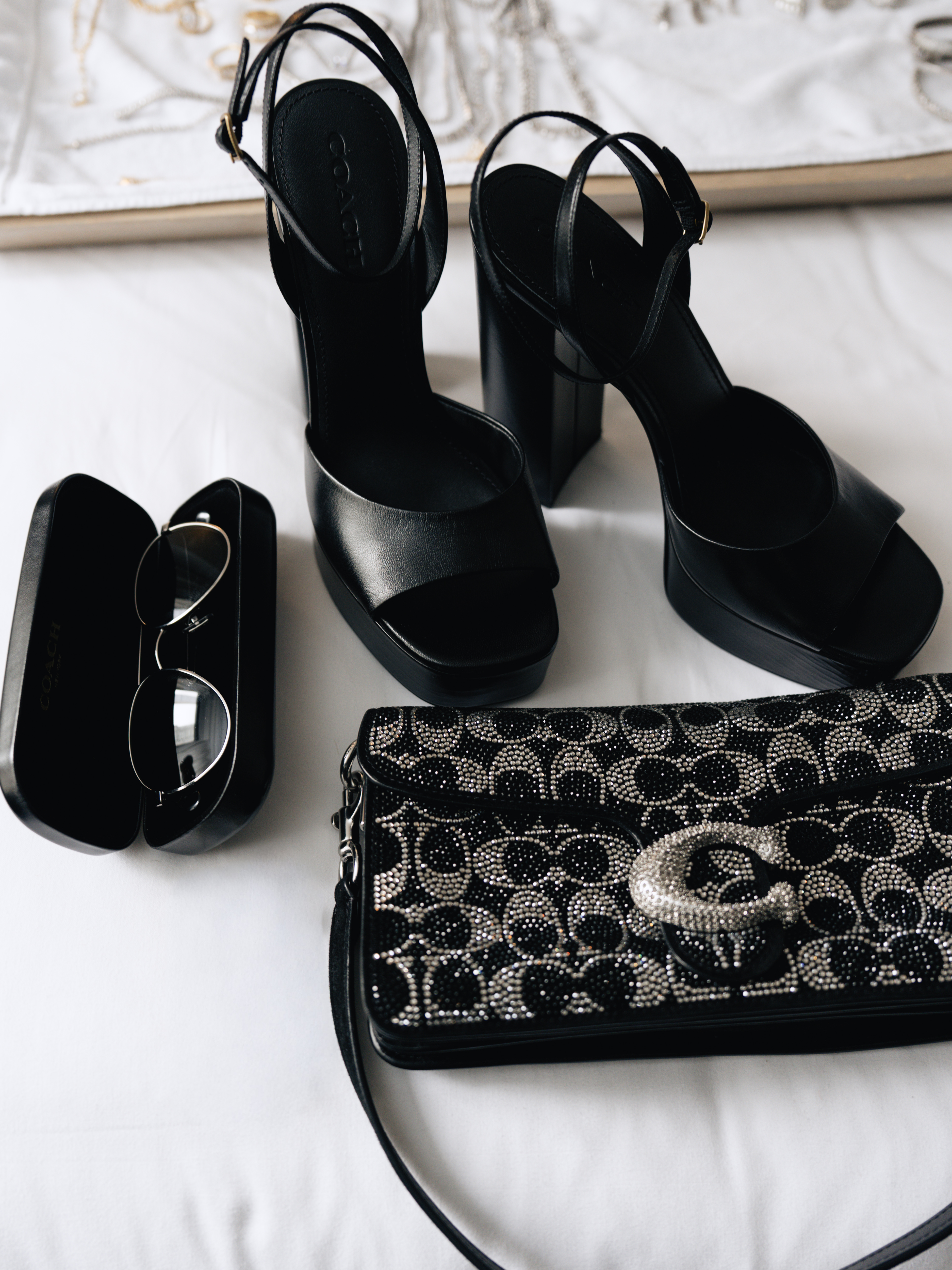 A close-up shot of Kiki Rice's shoes, sunglasses, and bag from Coach for the WNBA Draft.