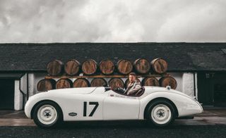 Jenson Button in a white car, brand ambassador of Coachbuilt blended Scotch whisky