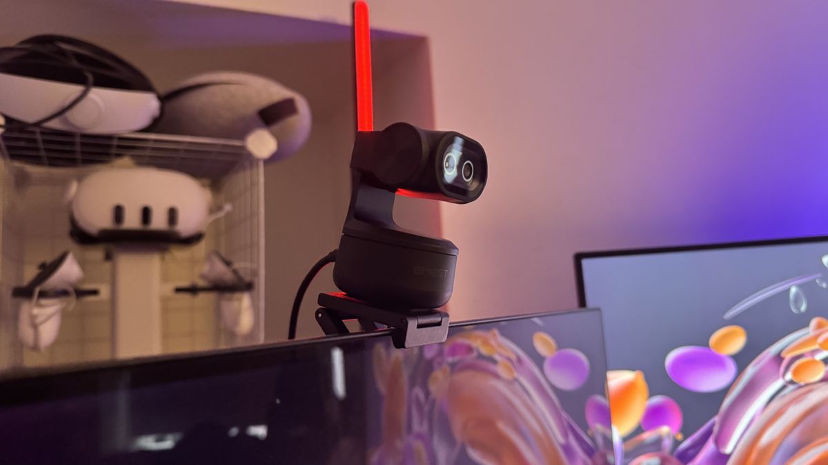 The Emeet Pixy 4K webcam from the side on a monitor, with lights and VR headsets behind it.