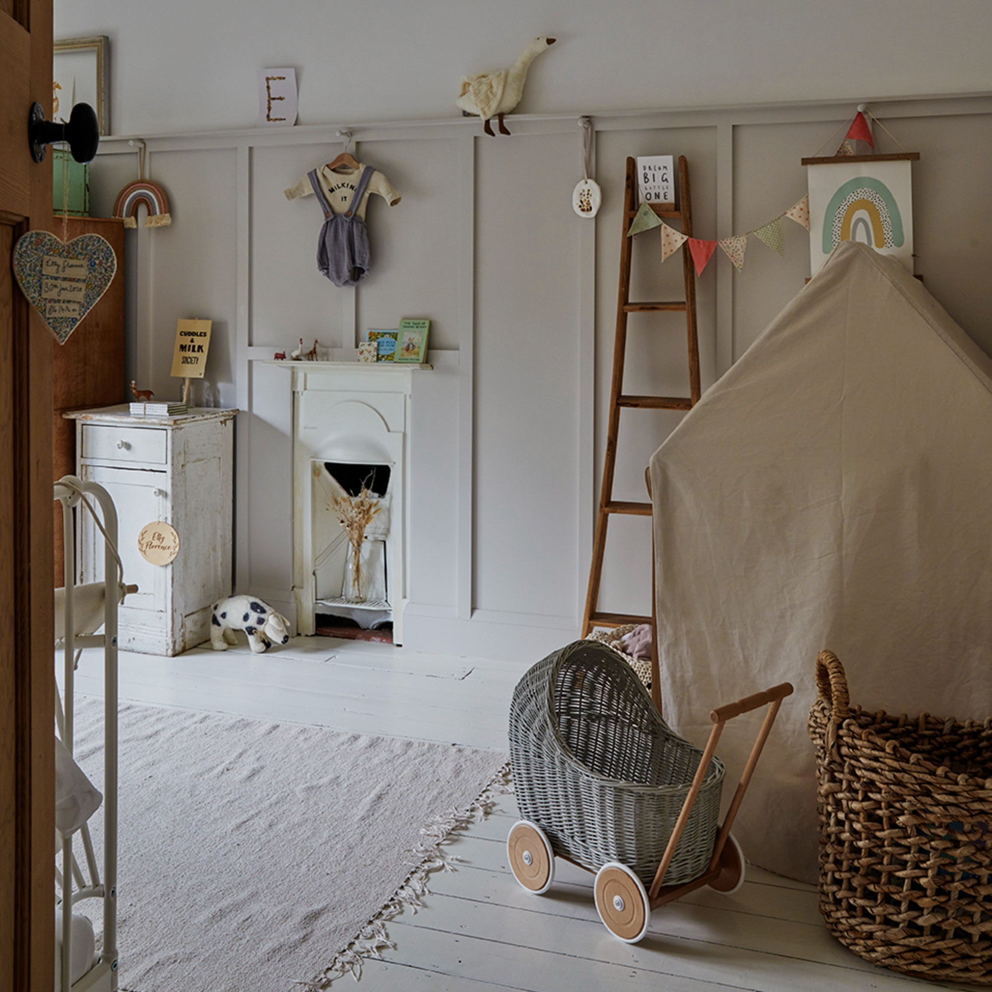 A neutral-coloured kids' room with a play area with a tent and panelled walls