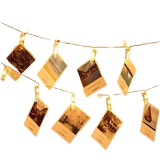 A string of fairy lights with photo clips and photos
