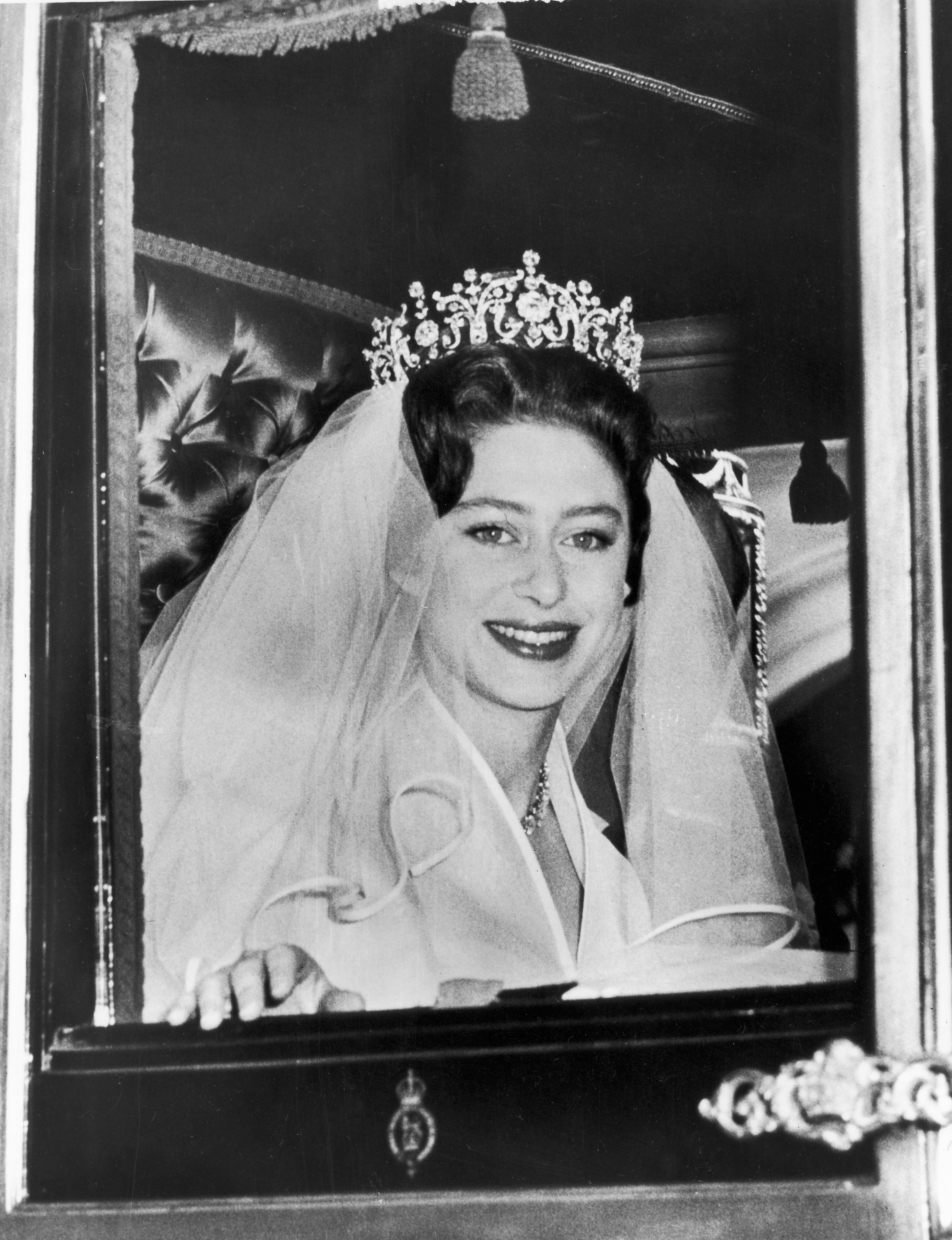 Princess Margaret wearing a tiara and wedding veil riding in a carriage