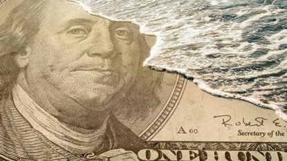 A wave washes over Ben Franklin's face on a $100 bill.