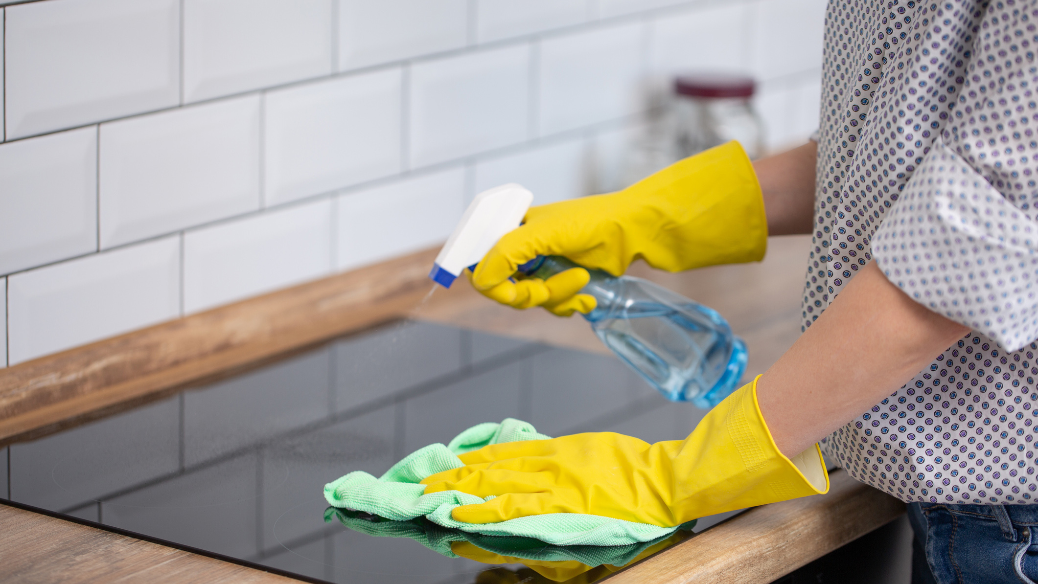 woman cleaning glass stovetop