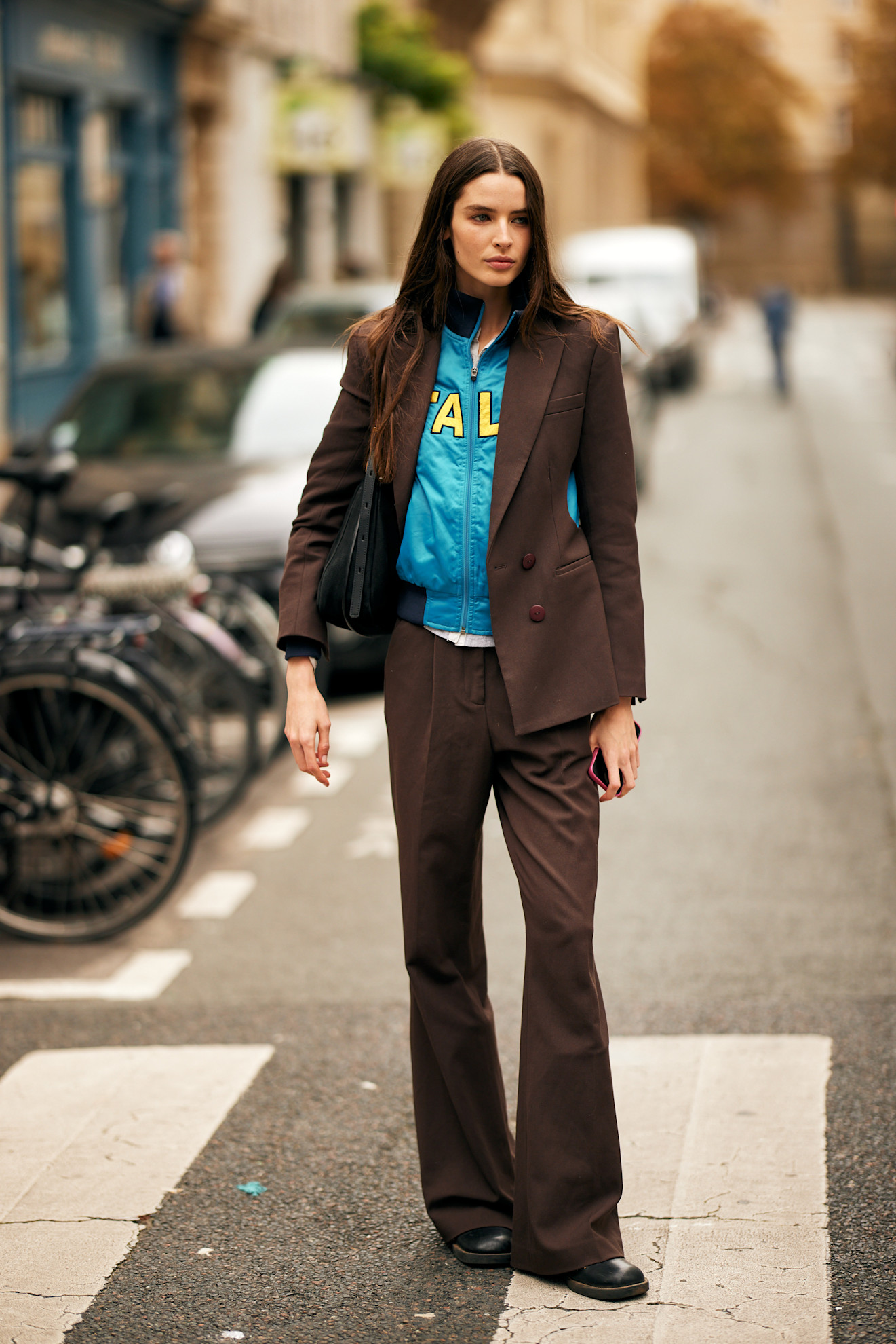 Woman in brown tailored suit with a blue sweatshirt