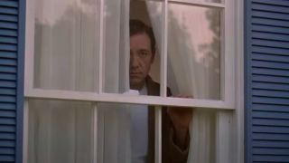 Kevin Spacey forlornly looks out a window in American Beauty.