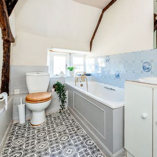 bathroom with white bathtub and monochrome tiles