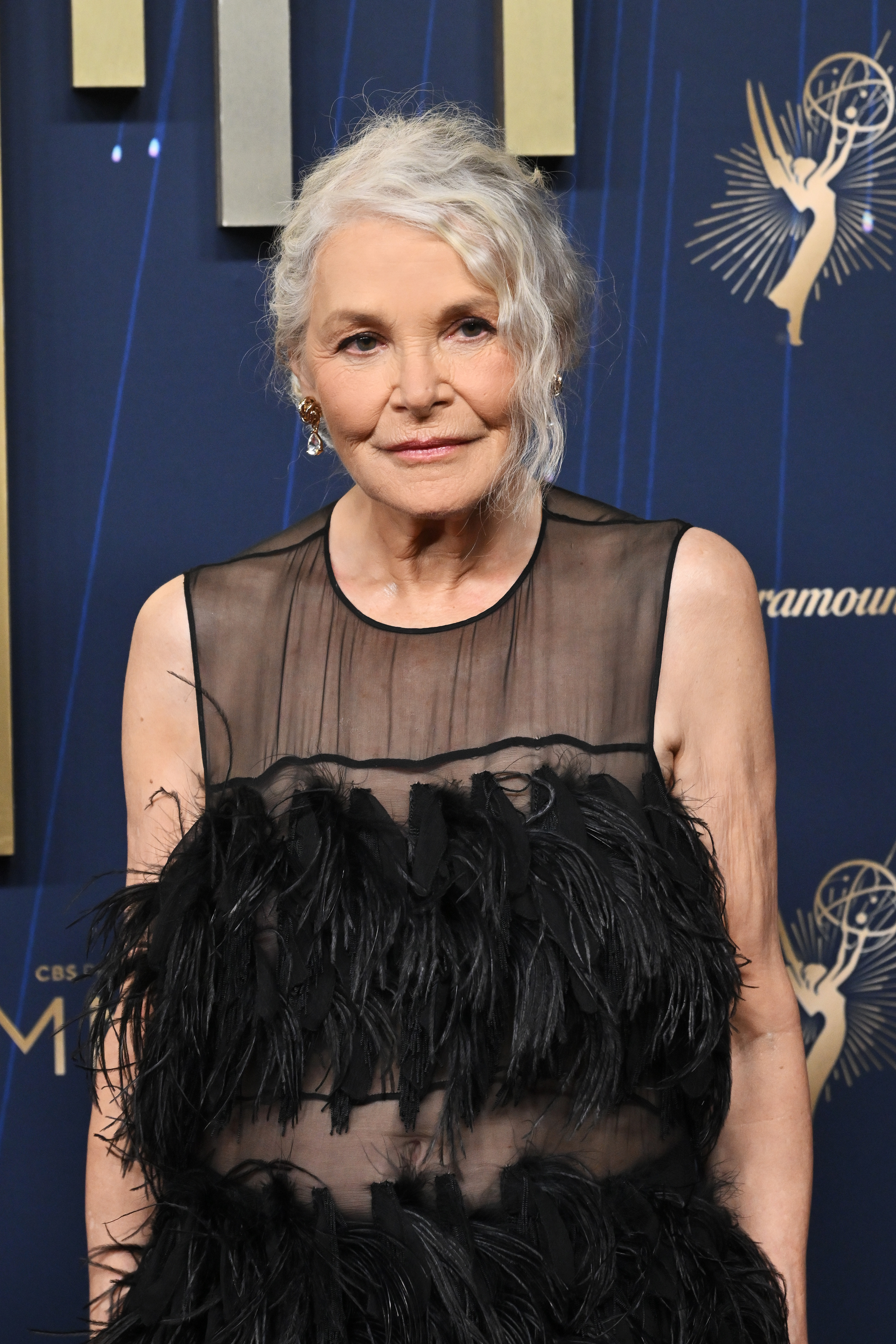 a woman with gray hair and a black sheer dress