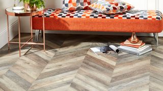 chevron pattern laminate flooring with orange day bed