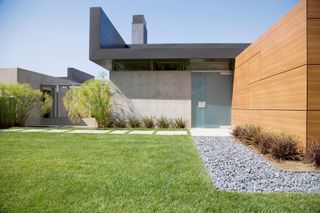 A gree lawn in front of a contemporary style newbuild house