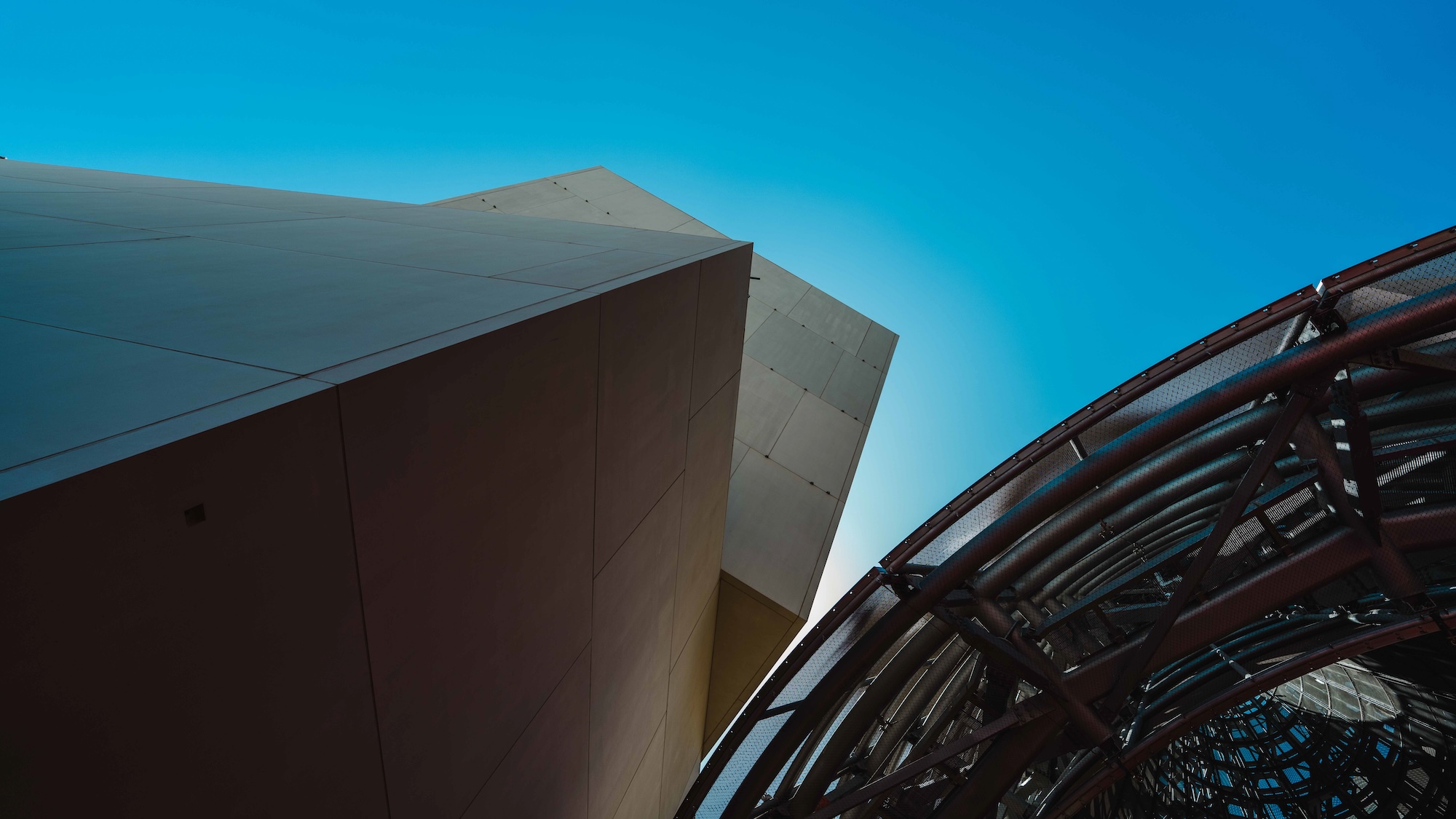 Guggenheim Abu Dhabi exterior images featuring a geometric assemblage of volumes made from steel glass timber and stone