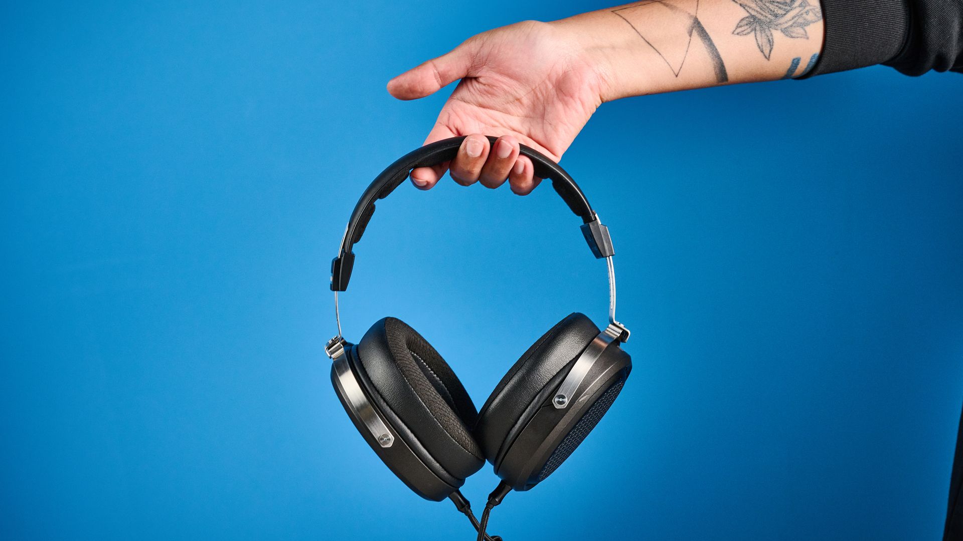 the fiio ft1 pro wired open-back headphones photographed with a blue tom's guide background