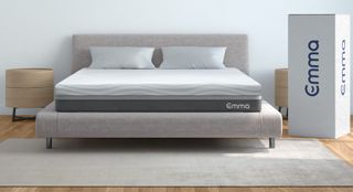 The Emma Mattress memory foam bed on a grey fabric frame placed on wooden floor