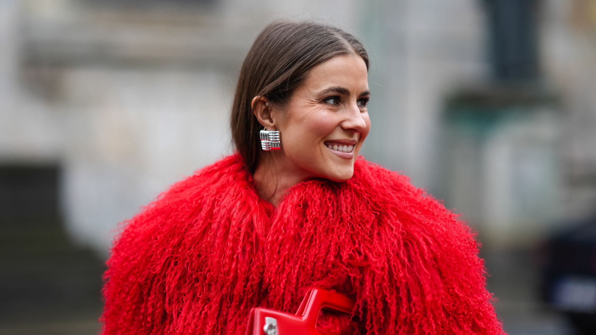 street style shot of woman wearing red furry coat