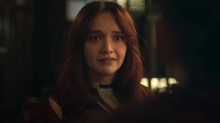 Olivia Cooke with red hair smiling in a dark restaurant in The Girlfriend