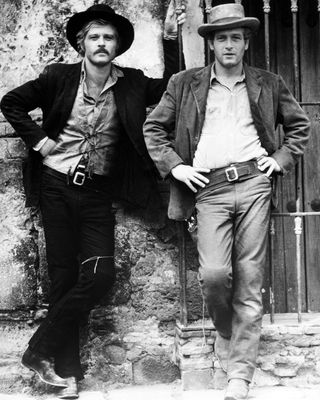 paul newman and robert redford pose next to a wall in a promotional shot for Butch Cassidy and the Sundance Kid (1969)