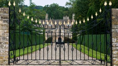 An iron gate protects a brick mansion.