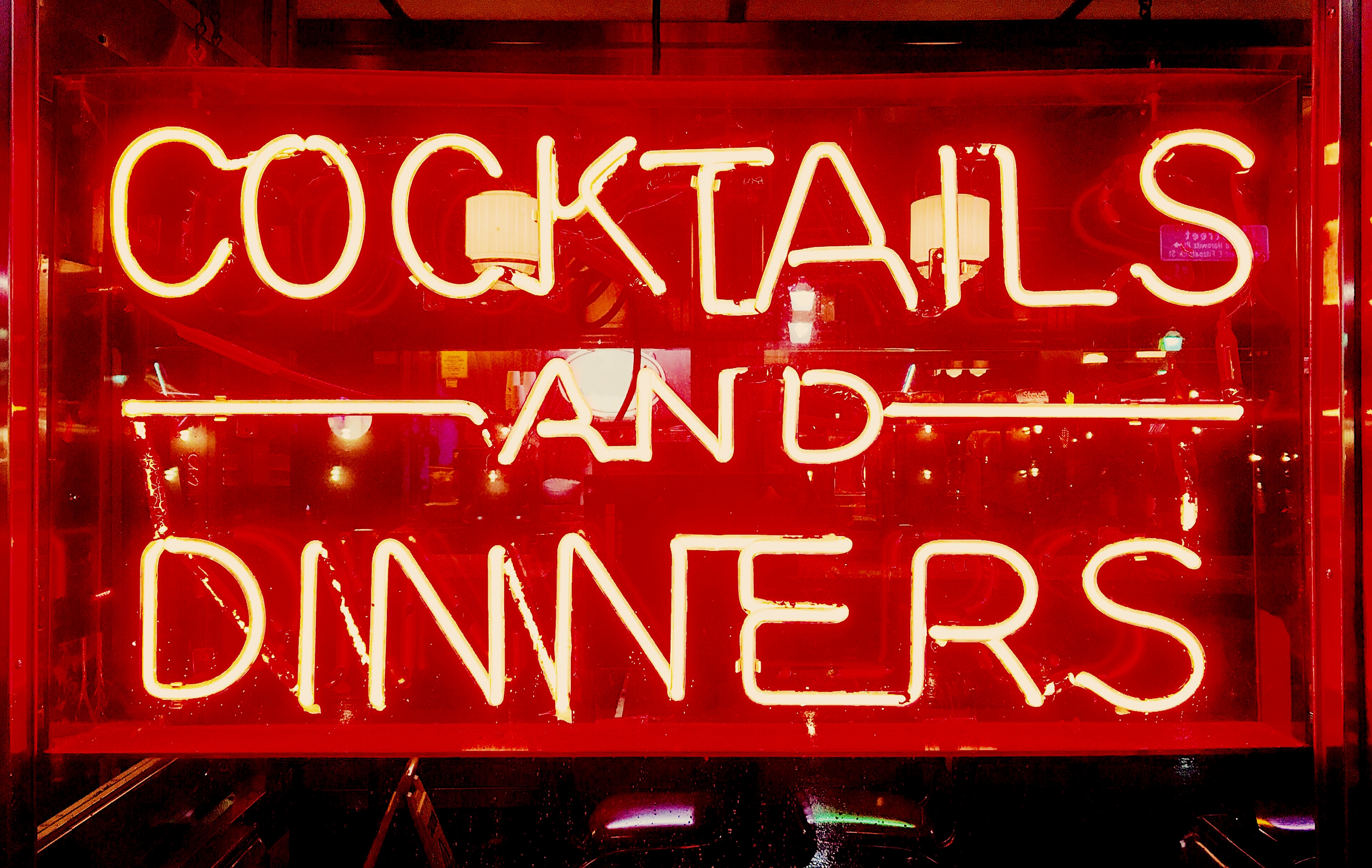A neon sign that says Cocktails and Dinners