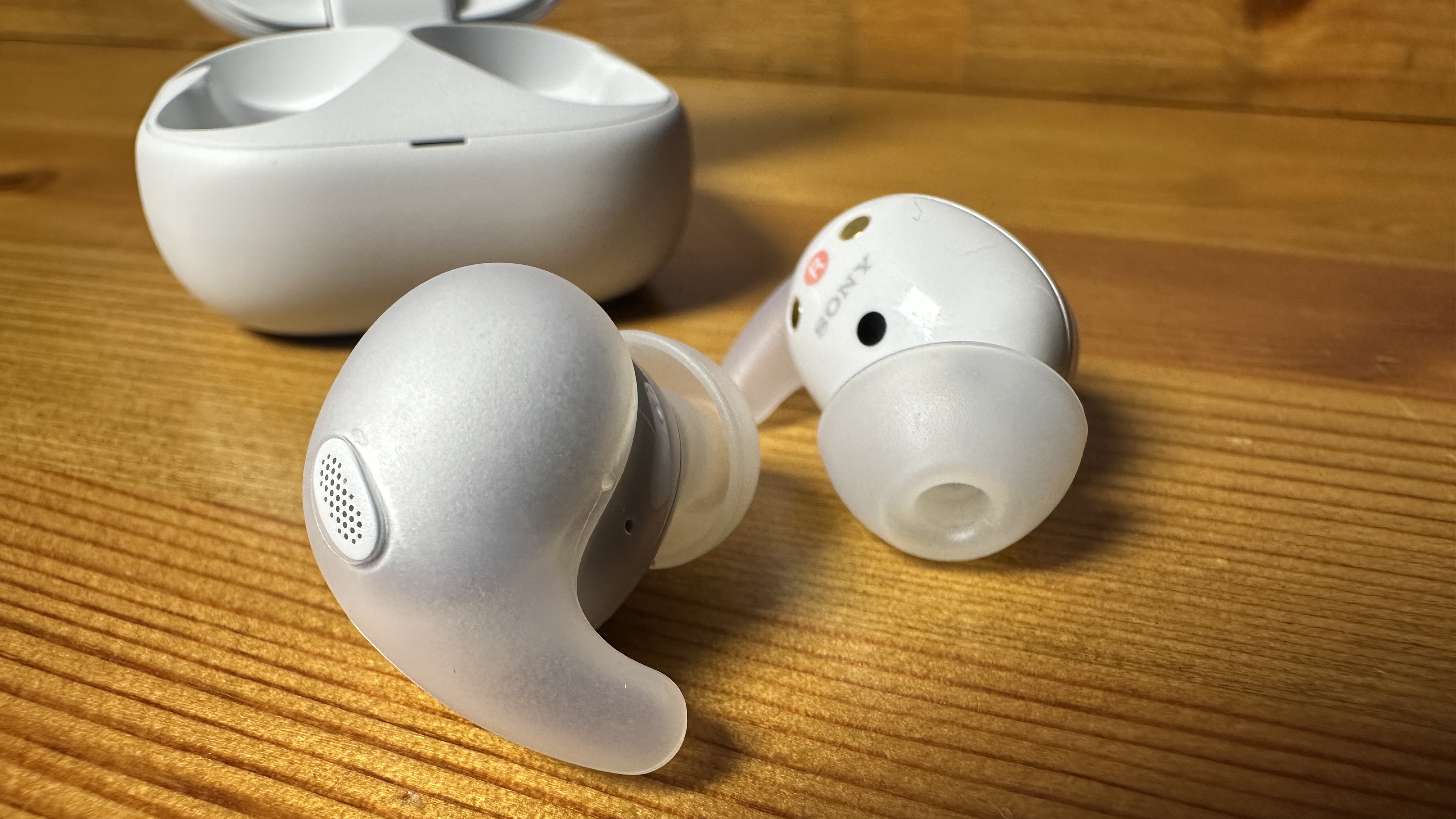 A close up of the Sony linkbuds fit earbuds next to their case