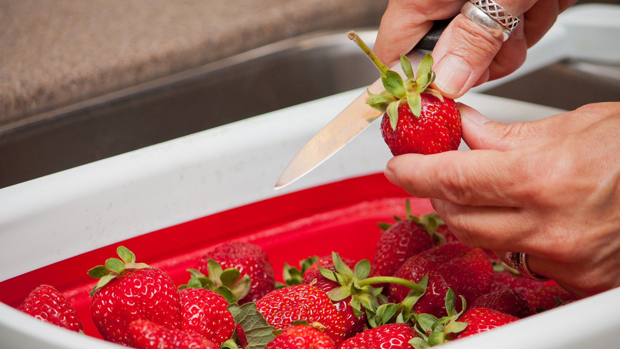 Cutting tops off strawberries