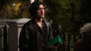 Felix holding a green clutch bag and looking confused in Too Much