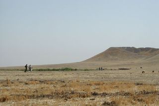 Archaeologists inspect the mound at Tell Brak, in northeastern Syria. The 283 million cubic foot (8 million cubic meter) mound is entirely artificial, accumulating over 6,000 years, as residents built on top of old mud brick buildings. 