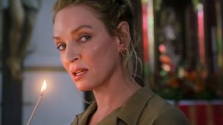 Discord (Uma Thurman) holding a lit matchstick in a scene from "The Old Guard 2"