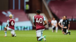 Both teams and match officials take a knee in support of the Black Lives Matter campaign as every player has their name replaced with the phrase Black Lives Matter during the Premier League match between Aston Villa and Sheffield United at Villa Park on June 17, 2020 in Birmingham, United Kingdom