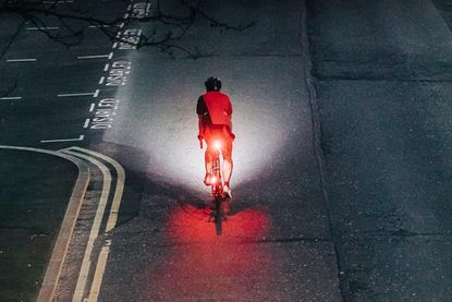 Cyclist riding through dark unlit streets using a magicshine seemee 200 rear light.