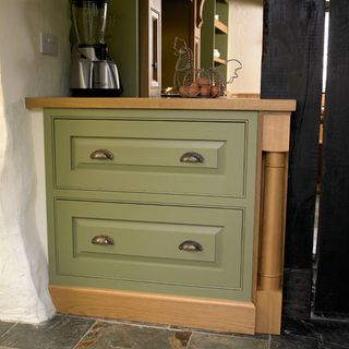 Green cabinet with white wall and mixer grinder