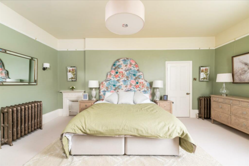 A bedroom with a lime green wall and bedsheet