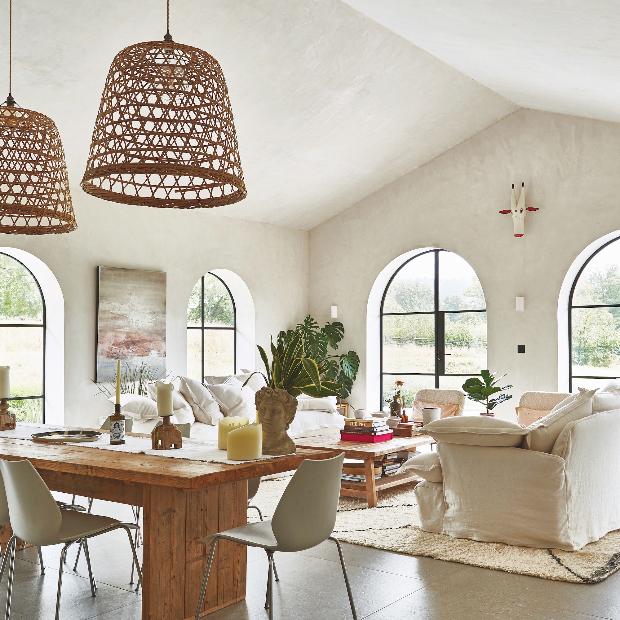 modern farmhouse style kitchen with wooden kitchen with large island and arched patio doors with seating area with white sofas