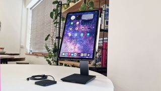 A photo of the PITAKA iPad charging stand and Pro case on a white table in a bright room
