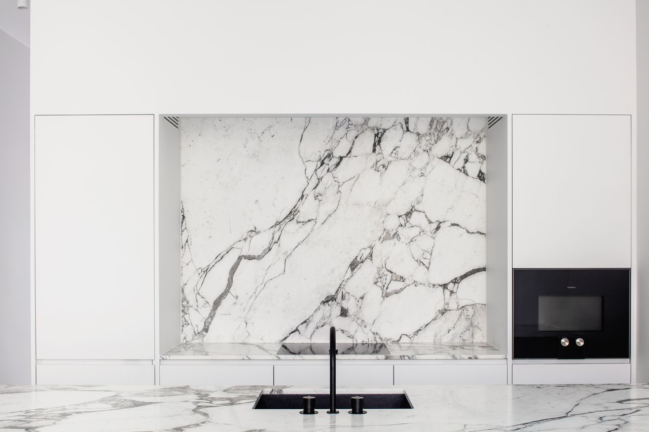 black sink in white marble kitchen