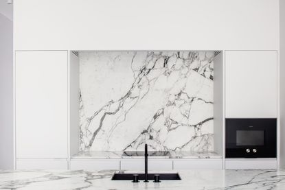 black sink in neutral kitchen with wood and grey