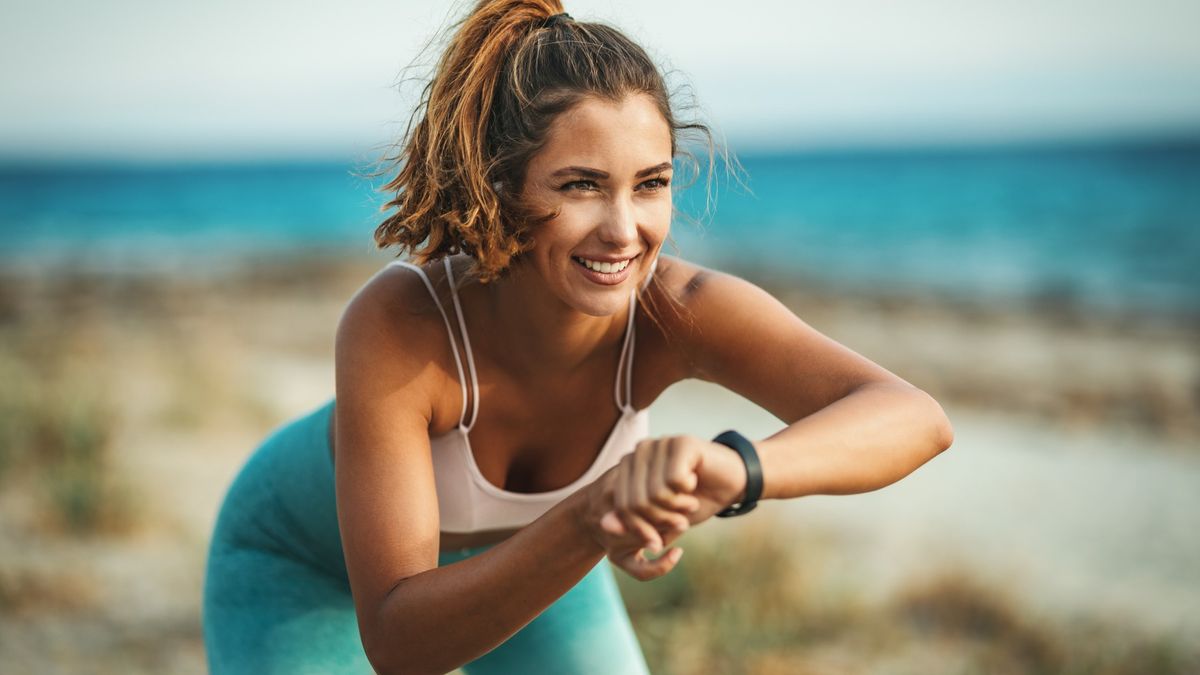 Happy woman checking sports watch