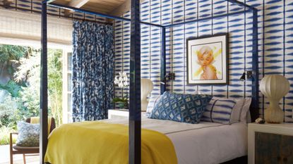 Large scale white and blue wallpaper and four poster bed