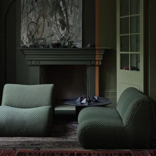 A living room colour drenched in green with Farrow & Ball's colour-blocked Reduced Green and Dibber paint shades, separated by a line in Marmelo