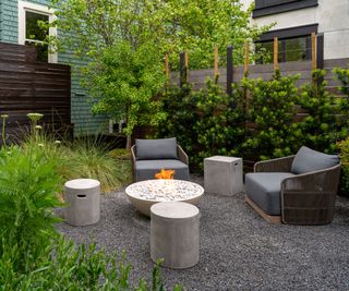 gravel patio seating area with fire pit in the center