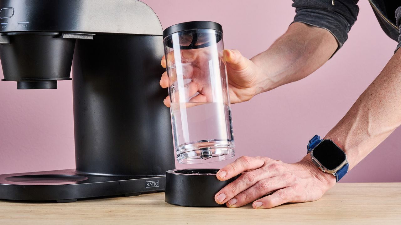 A man's hands insert the Ratio Four's water tank into its dock.
