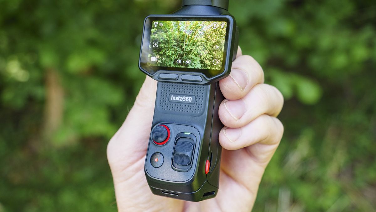 Closeup of the Insta360 Luna Ultra vlogging camera in person's hand, leafy background